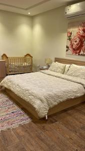 利雅德Strings Chalet的卧室配有一张大床,墙上挂有绘画作品