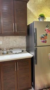 利雅德Strings Chalet的厨房配有不锈钢冰箱和木制橱柜