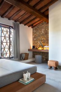 瓦尔的圣卡西亚诺萨尔瓦多妮卡酒店的一间卧室设有一张大床和石墙