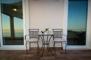 杜布罗夫尼克拉谷萨别墅酒店的门廊上的两把椅子和一张桌子