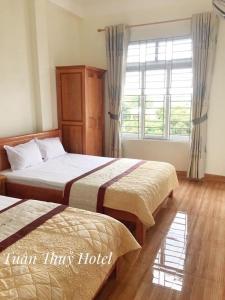 泉兰Tuân Thuỷ hotel đảo Quan Lạn的酒店客房设有两张床和窗户。