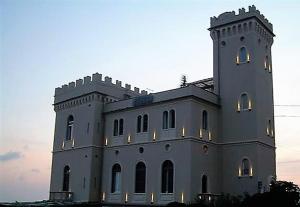 热那亚米拉马雷城堡酒店的一座白色的大建筑,灯火通明