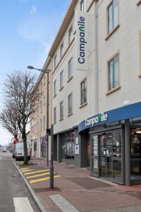 埃皮纳勒Campanile Epinal Centre - Gare的城市街道上的一座建筑,有商店