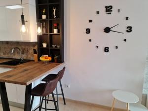 La EnviaSybarix Apartment: Precioso apartamento con vistas al golf y el mar的墙上的厨房配有大时钟