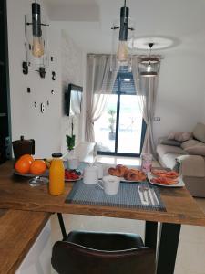 La EnviaSybarix Apartment: Precioso apartamento con vistas al golf y el mar的厨房配有餐桌和食物