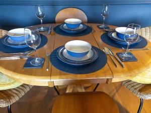 珀斯Paradise Place的一张木桌,上面放有盘子和酒杯