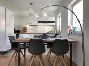 爱尔福特Ferienapartment Alma的厨房配有木桌和黑色椅子