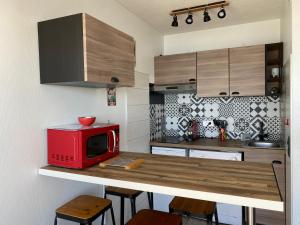 拉卡诺LACANAU FRONT DE MER的厨房在柜台上配有红色微波炉