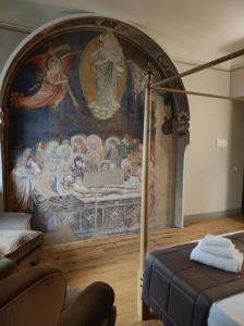 佛罗伦萨San Pier Novello in Oltrarno的卧室配有一张壁画床和一张沙发