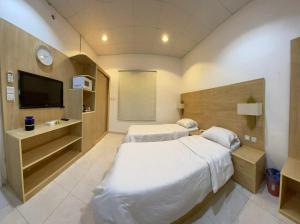 乌姆莱季شقق شاطئ النخيل的酒店客房设有两张床和电视。