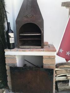 波索阿尔孔Estancia al pie de la Sierra del Pozo的旧砖炉,装有一瓶葡萄酒