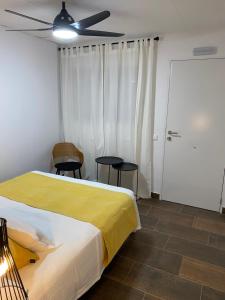 卡拉费尔罗维奥膳食公寓的一间卧室配有一张床、两把椅子和一个吊扇