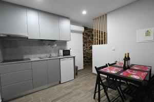 拉梅戈O Visconde - Alojamento local的厨房配有白色橱柜和桌椅