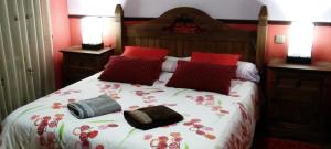 纳瓦夫里亚La Hijuela的一间卧室配有一张带红色枕头的床