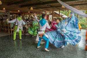 马尼萨莱斯Hacienda Charrascal Coffe Farm的一群穿着服装的人在人群前跳舞
