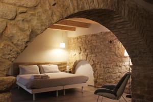 阿夸维瓦德莱丰蒂Albertario的卧室配有一张石墙床