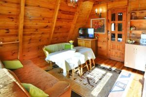 OsiekiHoliday home in Osieki near a lake的小屋内的客厅配有桌子和电视