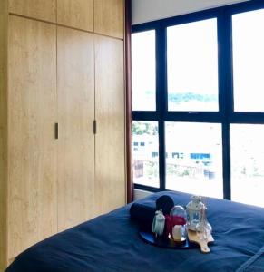 普崇Cozy Mayfair Homestay的一间卧室配有一张带蓝色床罩和电器的床。