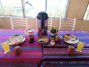 普诺Uros Suyawi Titicaca Lodge的餐桌,早餐包括面包和橙汁