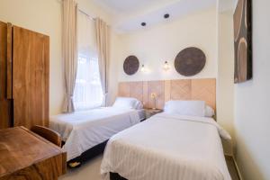 日惹Siji Gempol Vacation Home的一间卧室设有两张床、一张桌子和一个窗口