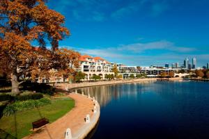 珀斯East Perth Suites Hotel的享有河流的景色,建筑背景
