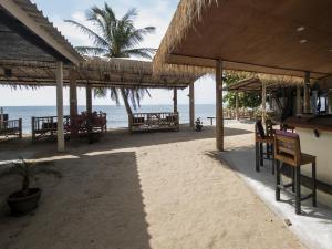 高兰Isara Lanta Beach Resort的海滩上设有桌椅,大海上设有沙滩