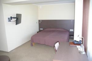 奥泰佩特瓦迪酒店的一间小卧室,配有一张床和一张桌子