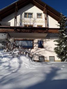 瓦门施泰纳赫Pension Waldeck Fleckl的雪上标有标志的建筑