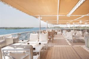 卢克索Jaz Regent Nile Cruise - Every Monday from Luxor for 07 & 04 Nights - Every Friday From Aswan for 03 Nights的船上的甲板上配有桌椅