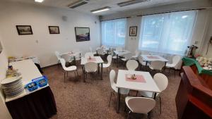 帕尔杜比采克里斯勒酒店的用餐室配有白色的桌子和白色的椅子