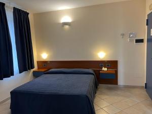 蒙特罗尼德阿尔比亚1000米丽雅酒店的一间卧室配有一张带蓝毯的床和一张书桌