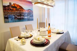 阿利坎特LUXURY New Apartment CITY CENTRE & BEACH, Alicante的一张桌子,上面有白色的桌布,上面有盘子和眼镜