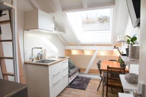 斯图加特gemütliches tiny apartment - nur 10min vom Zentrum的一个带水槽和窗户的小厨房