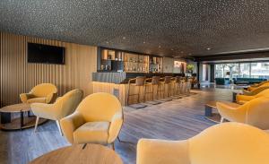 波尔图波尔图-图尔乐酒店的一间设有黄色椅子和酒吧的等候室