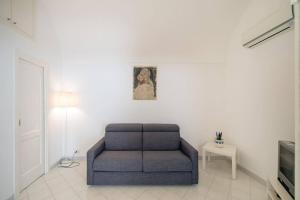 卡普里Casa Vacanza Al Centro di Capri的客厅配有蓝色椅子和电视
