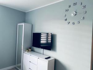 比亚韦斯托克2Lustra的一间设有冰箱和墙上时钟的房间