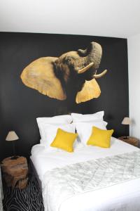 拉帕尔米雷Au Palmyre Hôtel的象头在床上方的墙上