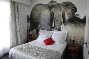 拉帕尔米雷Au Palmyre Hôtel的卧室的墙上挂有大象画