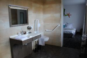 拉帕尔米雷Au Palmyre Hôtel的一间带水槽和卫生间的浴室以及一张床