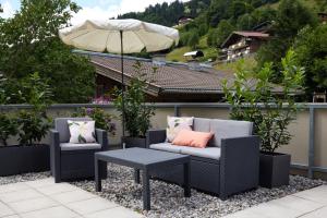 菲霍芬Kramerhaus Viehhofen的庭院配有两把椅子、一张桌子和一把遮阳伞