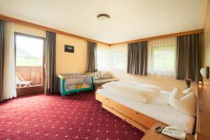施图拜河谷新施蒂夫特斯多斯勒酒店的一间卧室配有两张床和一张婴儿床。