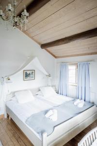 塔尔伯格Hotell Klockargården的卧室配有一张带蓝色窗帘的大型白色床