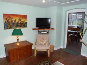 North LydburyKwerky Cottage的客厅配有电视、椅子和台灯