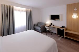 卡塔赫纳斯考特而卡洛斯三世酒店的酒店客房配有一张床、一把椅子和一张书桌
