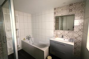 奥贝奈Gîte Sainte Odile的带浴缸、水槽和镜子的浴室