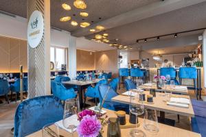 韦斯特兰I LOVE SYLT Hotel Terminus ADULTS ONLY的一间配备有蓝色椅子和桌子及桌面的用餐室