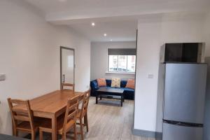 Theale2 BED 2 BATH & FREE PARKING - 10 MINS TO MADEJSKI STADIUM的厨房以及带桌子和冰箱的用餐室