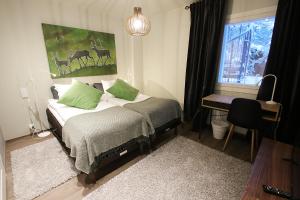 列维修鲁波罗酒店的一间卧室配有一张带绿色枕头的床和一扇窗户