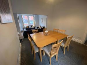 布莱克浦Blackpool Abode - Palatine House的一间带木桌和椅子的用餐室