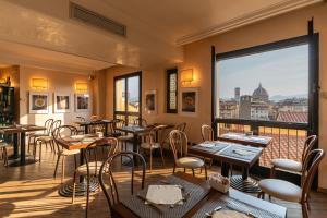 佛罗伦萨B&B Hotel Firenze Pitti Palace al Ponte Vecchio的一间带桌椅的餐厅以及一个阳台